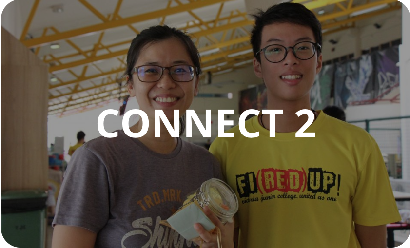 Two smiling young people wearing glasses stand together indoors with bold text reading CONNECT 2 overlaid.